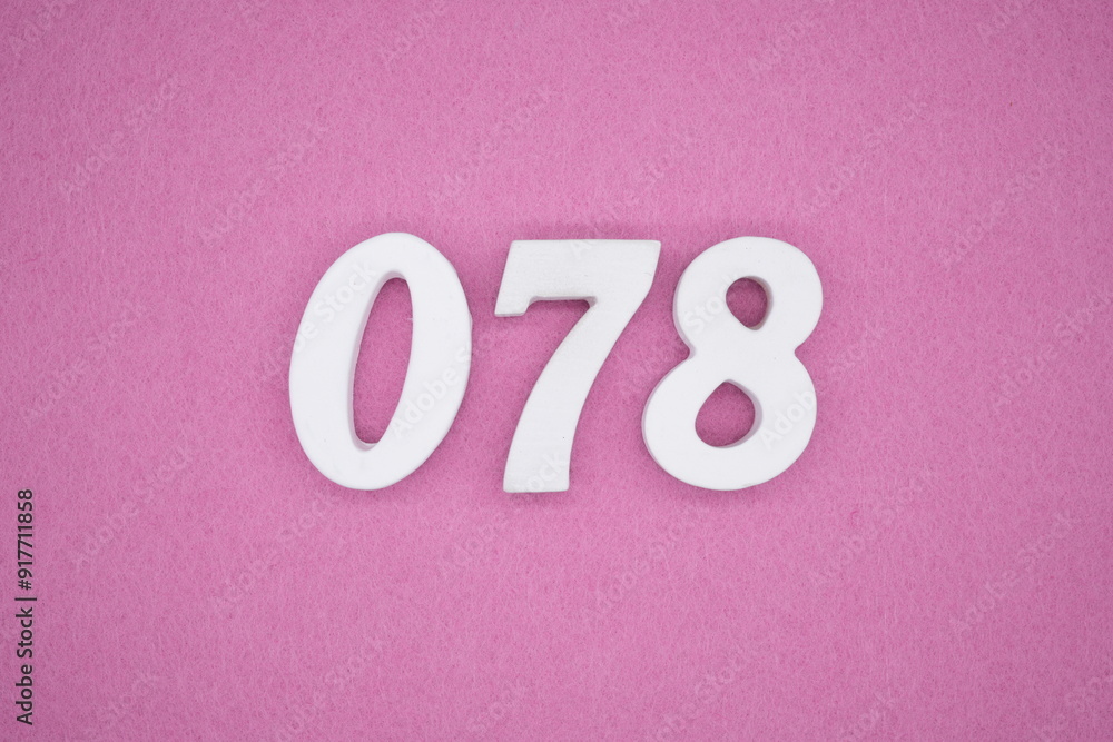 The numbers are made of white painted wood. Laying on the floor was pink paper. The numbers are made of white painted wood. Laying on the floor was pink paper.