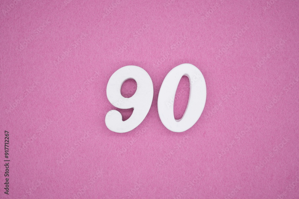 The numbers are made of white painted wood. Laying on the floor was pink paper. The numbers are made of white painted wood. Laying on the floor was pink paper.