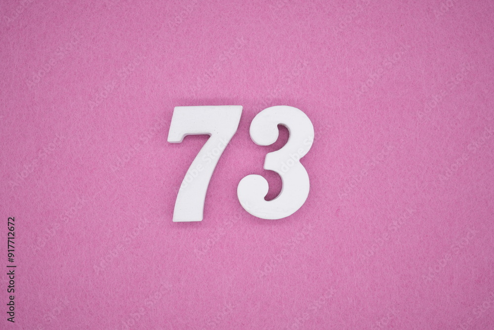 The numbers are made of white painted wood. Laying on the floor was pink paper. The numbers are made of white painted wood. Laying on the floor was pink paper.