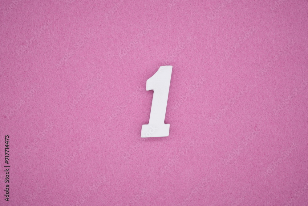 The numbers are made of white painted wood. Laying on the floor was pink paper. The numbers are made of white painted wood. Laying on the floor was pink paper.