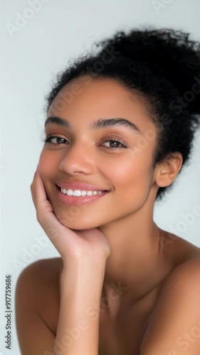 Young woman with glowing skin against a light background, vertical shot