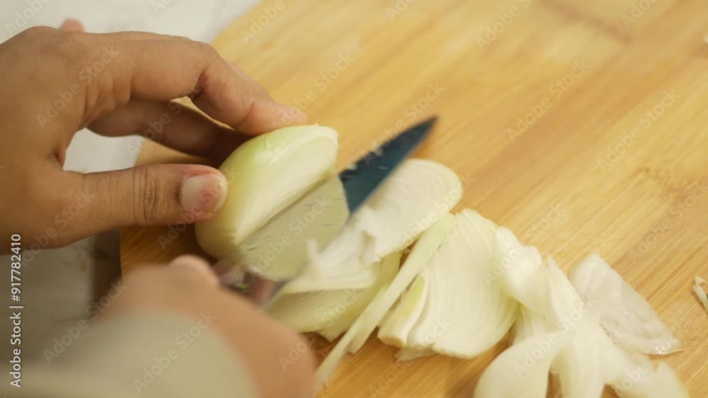 Carefully Chopping Onion with a Sharp Knife on a Sturdy Wooden Cutting Board Surface Carefully Chopping Onion with a Sharp Knife on a Sturdy Wooden Cutting Board Surface