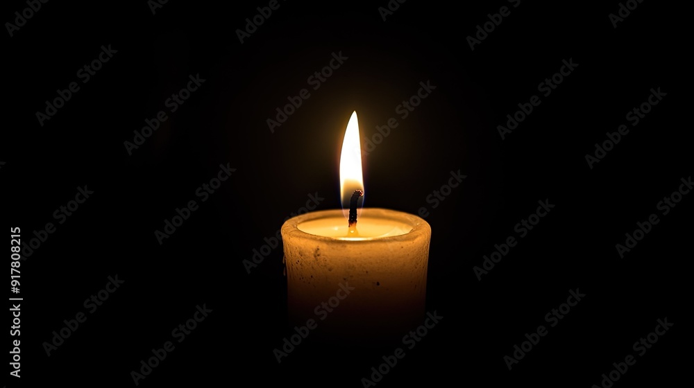 A single candle burns in the darkness, its light creating a calm, peaceful ambiance. A single candle burns in the darkness, its light creating a calm, peaceful ambiance.