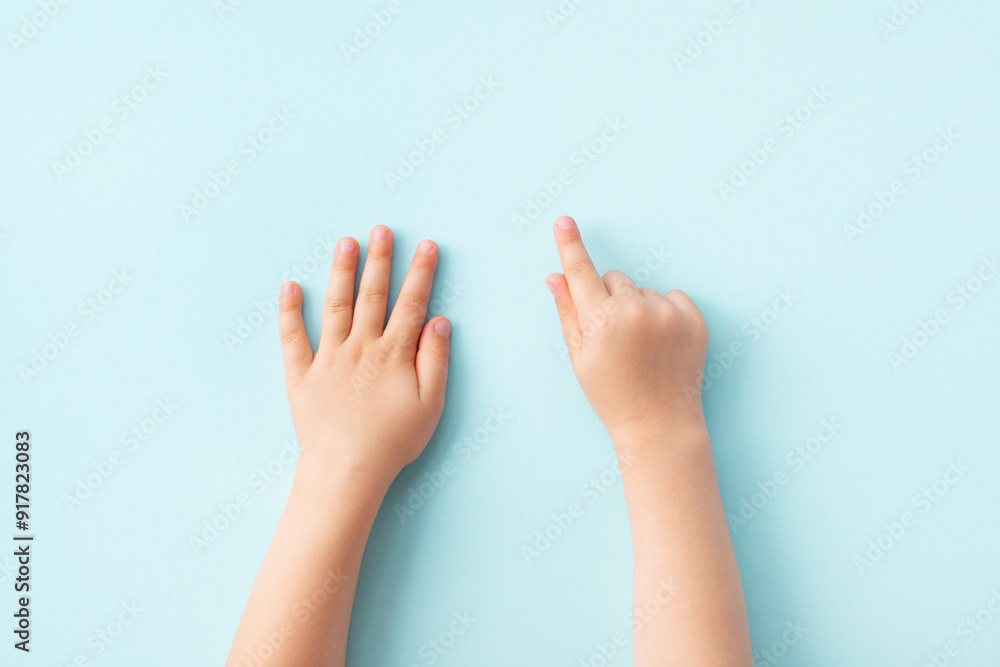 Small child hands on blue background top view. Skin care, family, playing and education template concept. Small child hands on blue background top view. Skin care, family, playing and education template concept.