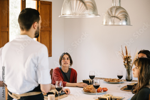 Private chef serves meal to friends at a stylish home dinner