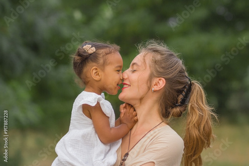 Mother and child. Happy mom and daughter rub and kiss with their noses. Mothers Day. Daughter's Day photo