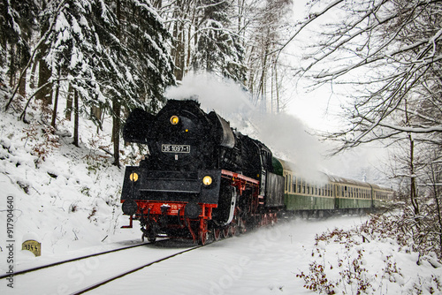 German steam express locomotive driving through a snowy family