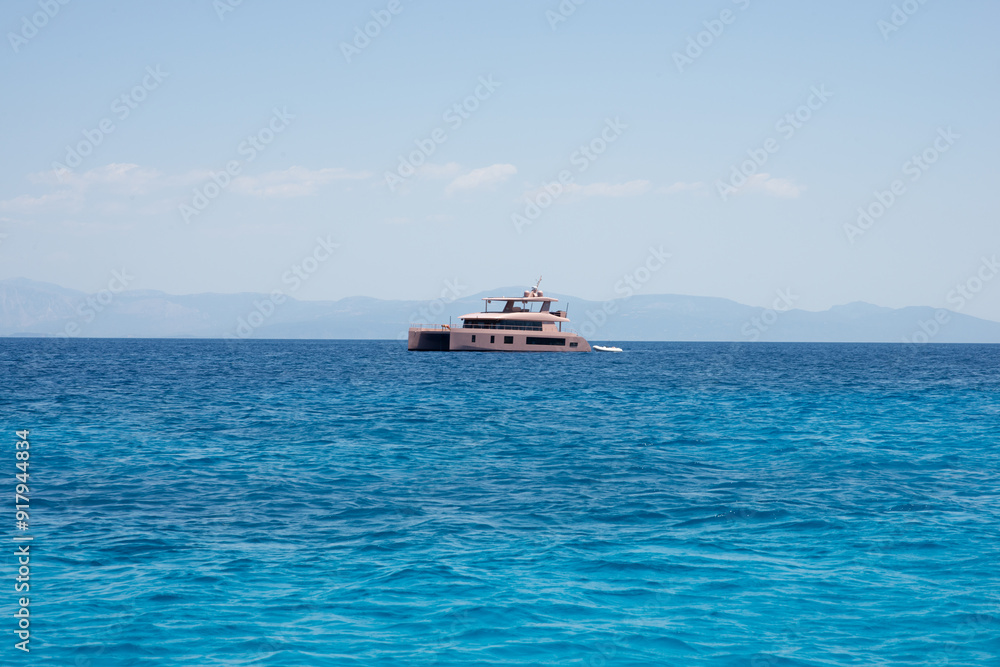 Pink luxury catamaran sailing in a summer day on crystal sea or ocean Pink luxury catamaran sailing in a summer day on crystal sea or ocean