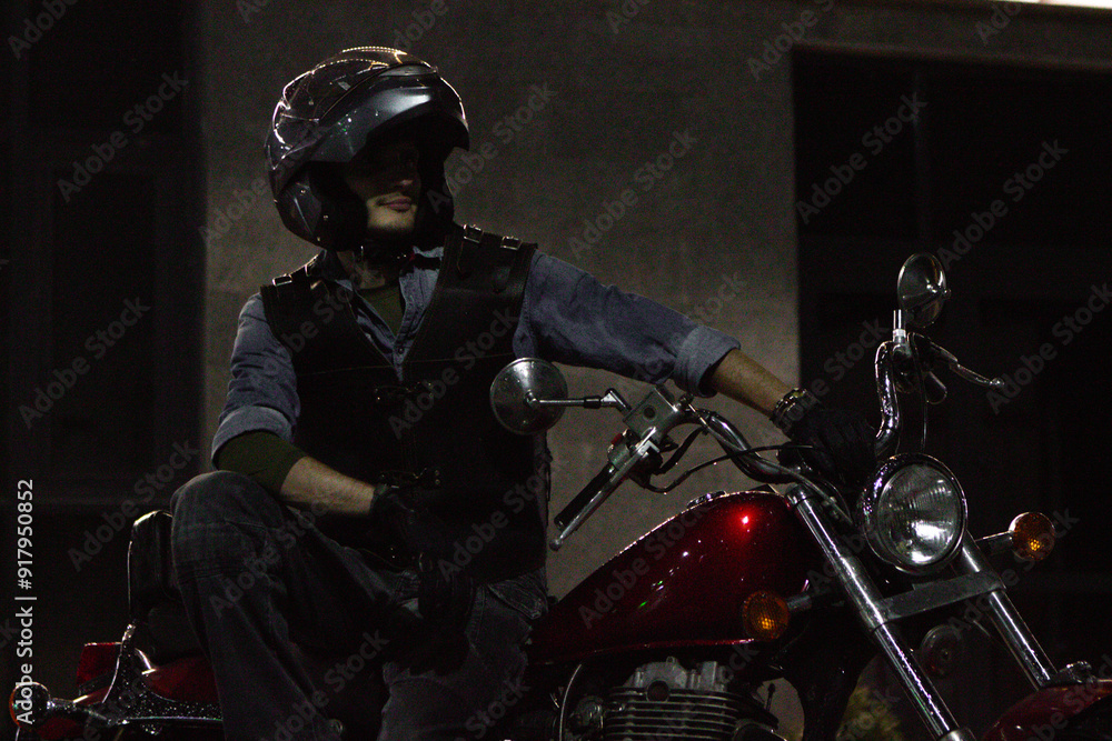 a man on a red chopper motorcycle. guy on a bike at night. a man on a red chopper motorcycle. guy on a bike at night.