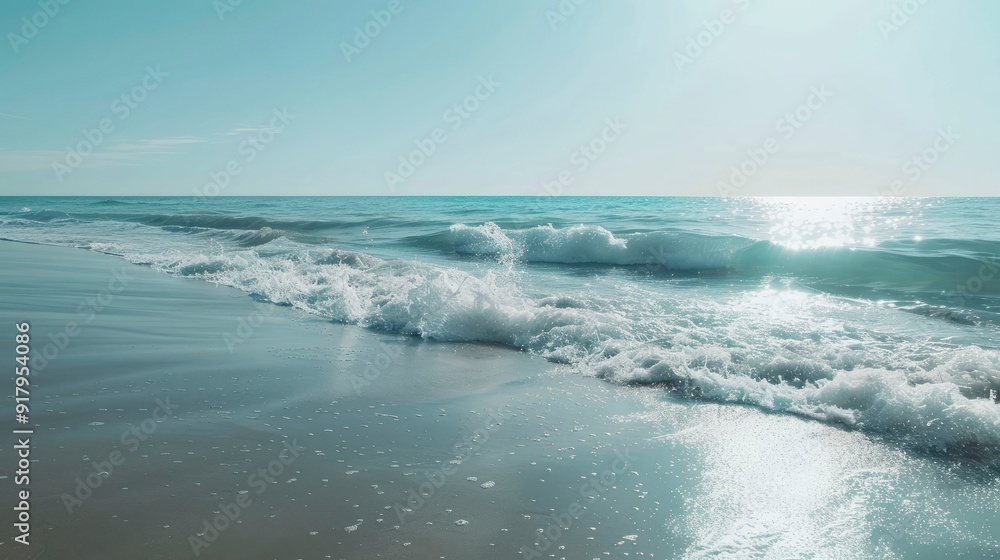 A serene beach with gentle waves and a clear blue sky.