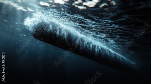 A submarine gliding through dark waters with bubbles trailing behind and light beams penetrating from the surface, creating a serene and mysterious underwater scene. photo