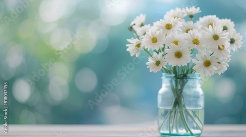 White Hydrangeas in a Clear Vase on a Soft Blue Surface With Natural Light