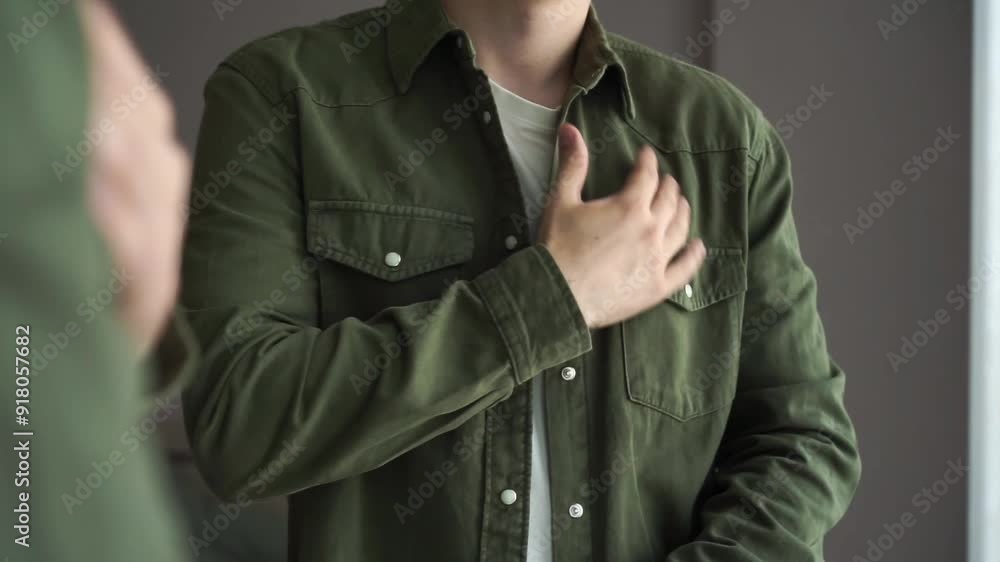 A young guy in front of a mirror in a green shirt A young guy in front of a mirror in a green shirt