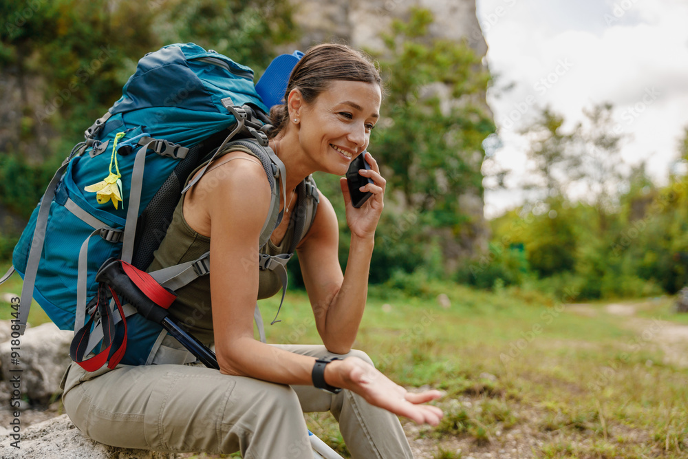 A hiker is taking a phone call while enjoying a beautiful outdoor adventure in nature A hiker is taking a phone call while enjoying a beautiful outdoor adventure in nature
