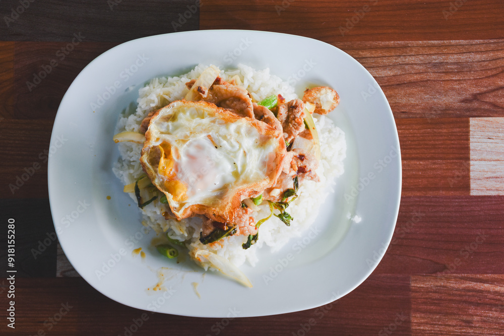Pork with basil and fried egg on rice is ready to eat on the table. Pork with basil and fried egg on rice is ready to eat on the table.