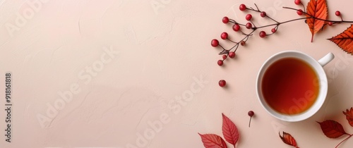 Warm Cup of Tea Surrounded by Autumn Leaves and Berries on a Soft Background