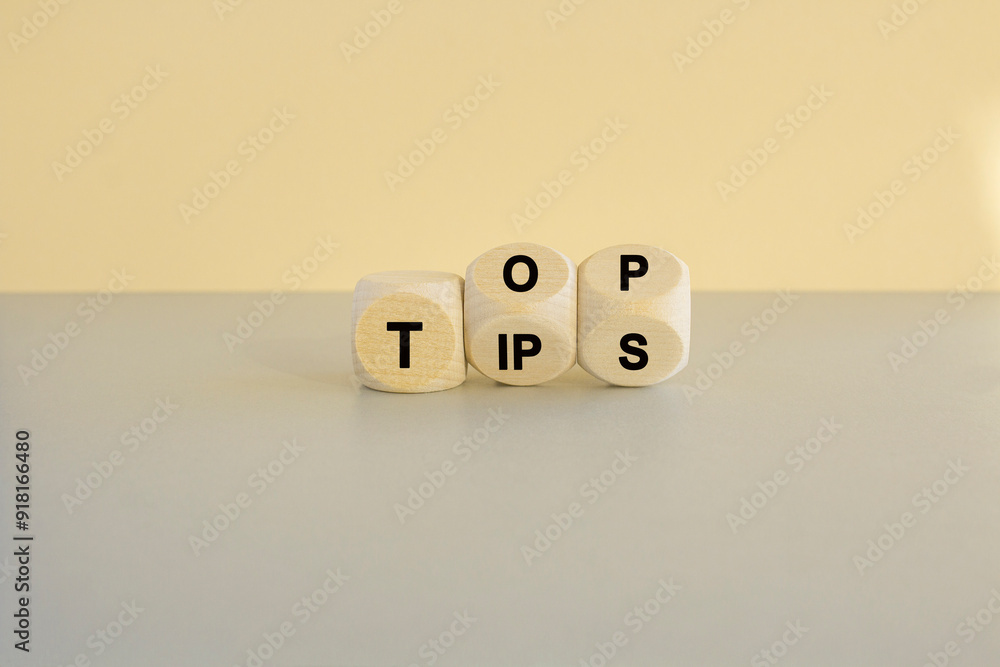 Top tips symbol. Turned wooden cubes with words 'Top tips'. Beautiful grey table, beige background. Top tips and business concept.