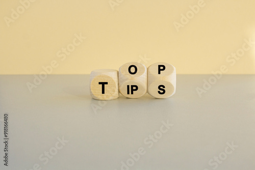 Obraz na płótnie Top tips symbol. Turned wooden cubes with words 'Top tips'. Beautiful grey table, beige background. Top tips and business concept. w salonie