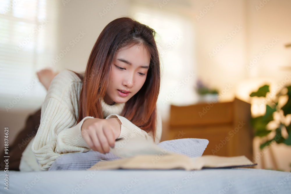 Young asian women in sweater lying on comfortable couch to enjoying and happiness with reading literature book while relaxation and doing activity to spending time with slow life lifestyle at home Young asian women in sweater lying on comfortable couch to enjoying and happiness with reading literature book while relaxation and doing activity to spending time with slow life lifestyle at home