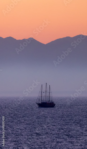 Sailboat in the Ionian Sea with Mountain Landscape Background. Twilight Sunrise Sky. photo