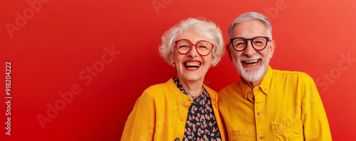 Crazy smiling senior couple, isolated red color background, image with space for text