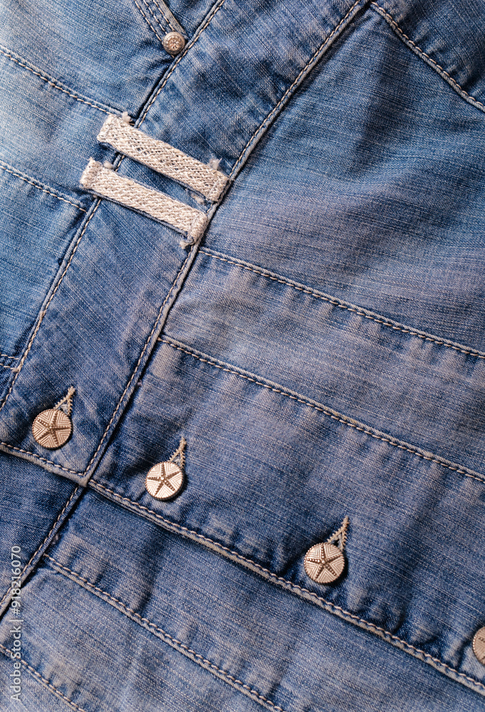 Fototapeta premium Detailed shot of a blue denim jacket with metal buttons
