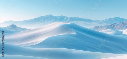 A panoramic view of a snow capped mountain range under a clear blue sky. The snow covered peaks rise up to the sky, creating a majestic and breathtaking landscape.