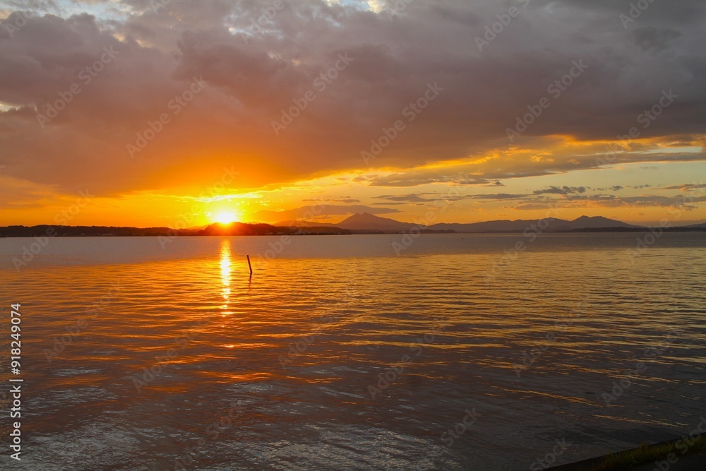 Sunset on a lake with the sky and reflection on water turning orange Sunset on a lake with the sky and reflection on water turning orange