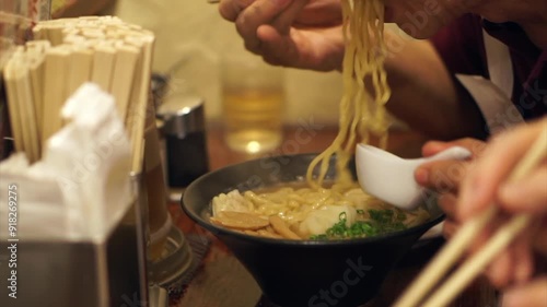 Senior elderly eating hot ramen noodle with chopsticks in Japanese restaurant