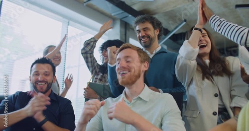 Team building moment. Multi-ethnic group of people exclaiming loudly after looking at monitor. Finding mistake together. Correct solution. Programmers happy about positive result of major problem.