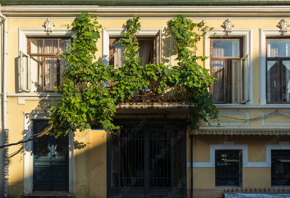 Obraz premium City view on a sunny day. Modern building and houses against the blue sky.
