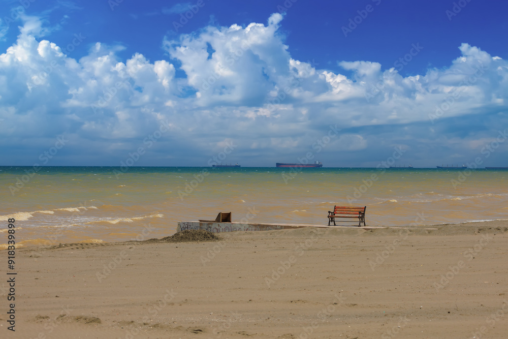 Wooden benches and sun loungers for relaxing on the embankment near the sea, public places Wooden benches and sun loungers for relaxing on the embankment near the sea, public places