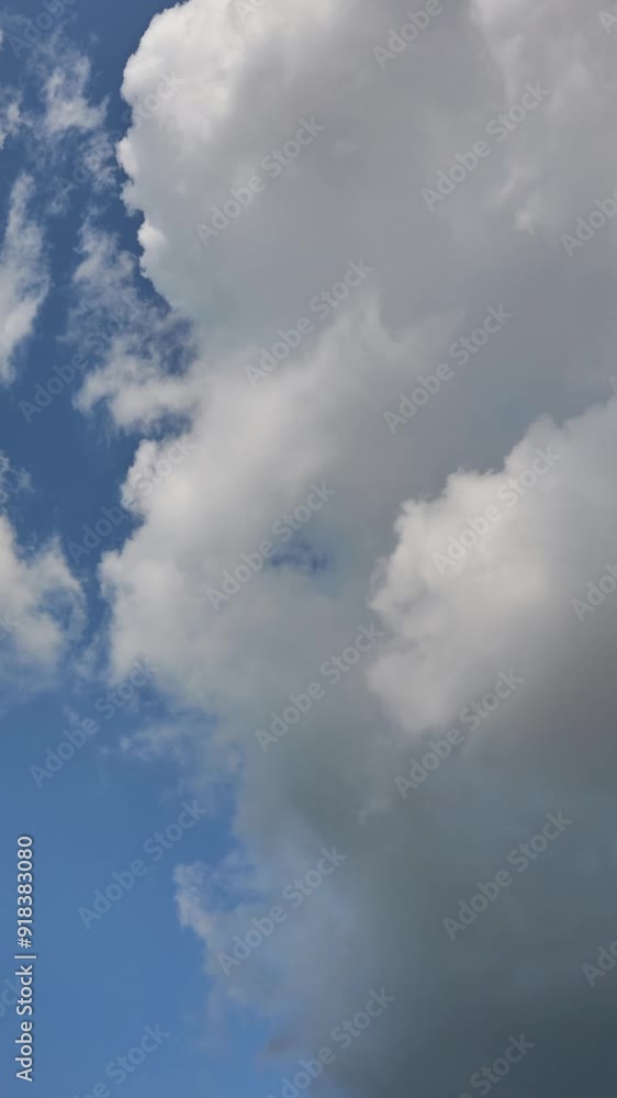 A timelapse of white clouds against a blue sky on a warm sunny summer day. Fluffy clouds float across the sky. A timelapse of white clouds against a blue sky on a warm sunny summer day. Fluffy clouds float across the sky.