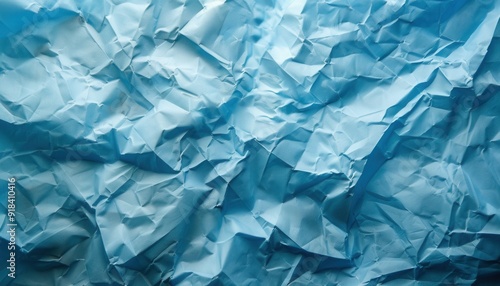 Crumpled blue paper texture with varying shades and patterns