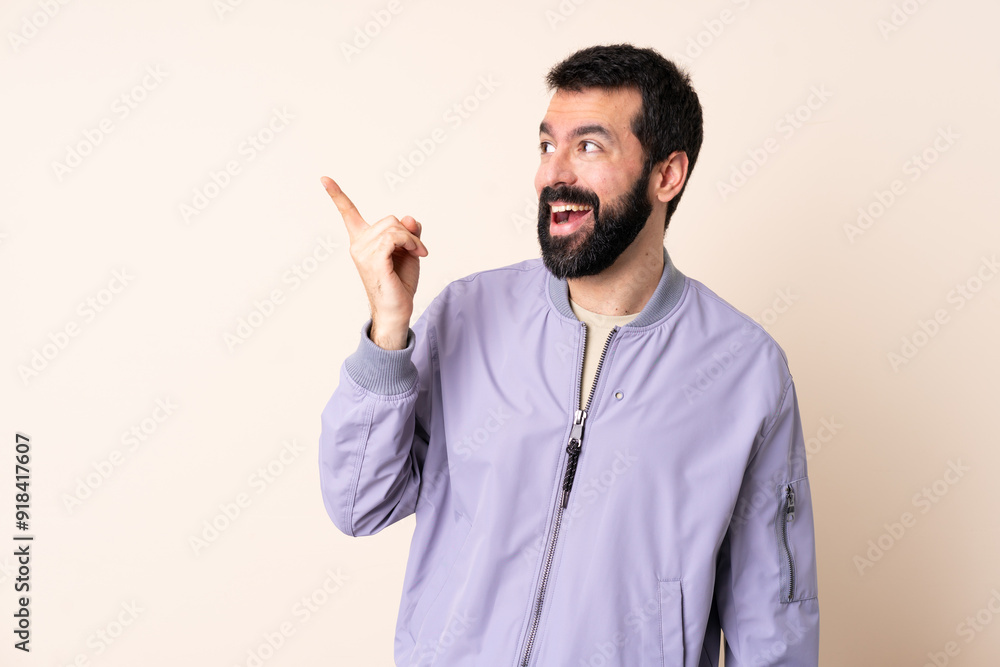 Caucasian man with beard wearing a jacket over isolated background intending to realizes the solution while lifting a finger up Caucasian man with beard wearing a jacket over isolated background intending to realizes the solution while lifting a finger up