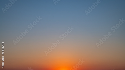 Natural background, sky at sunrise or sunset, color gradient from orange to blue, delicate and smooth transition