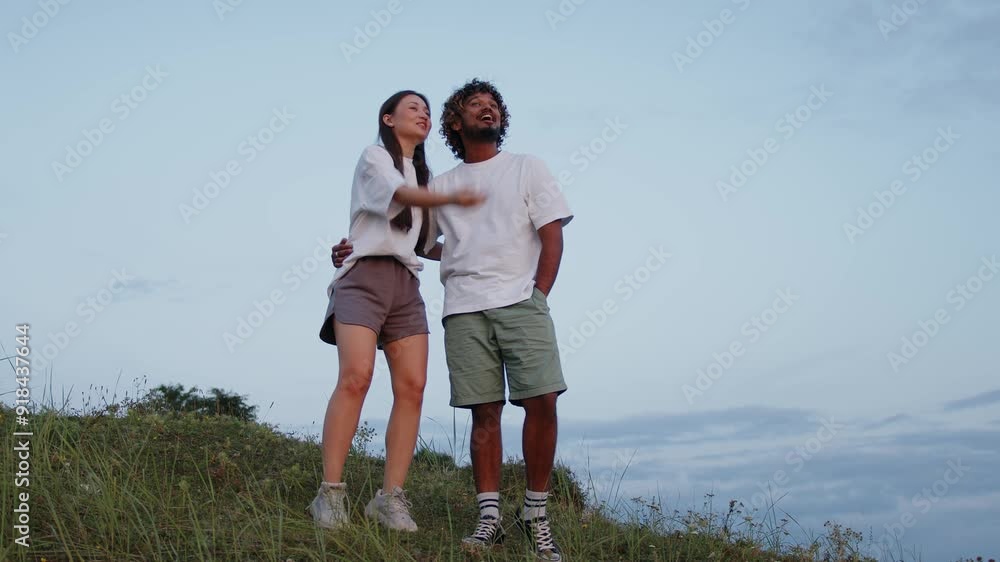 Happy multiracial couple Arab man and Asian woman taking selfie on phone, spending time in nature.