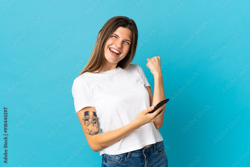 Young slovak woman isolated on blue background with phone in victory position Young slovak woman isolated on blue background with phone in victory position