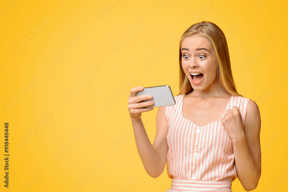 Emotional Teen Girl Rejoicing Success With Smartphone In Hands, Standing Over Yellow Background, Closeup Emotional Teen Girl Rejoicing Success With Smartphone In Hands, Standing Over Yellow Background, Closeup