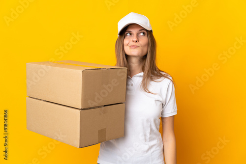 Foto Young Slovak delivery woman isolated on yellow background and looking up