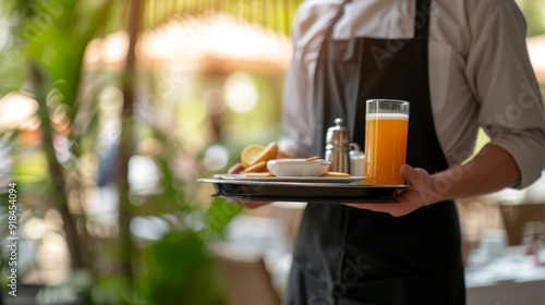 A professional waiter holding a tray with drinks or food