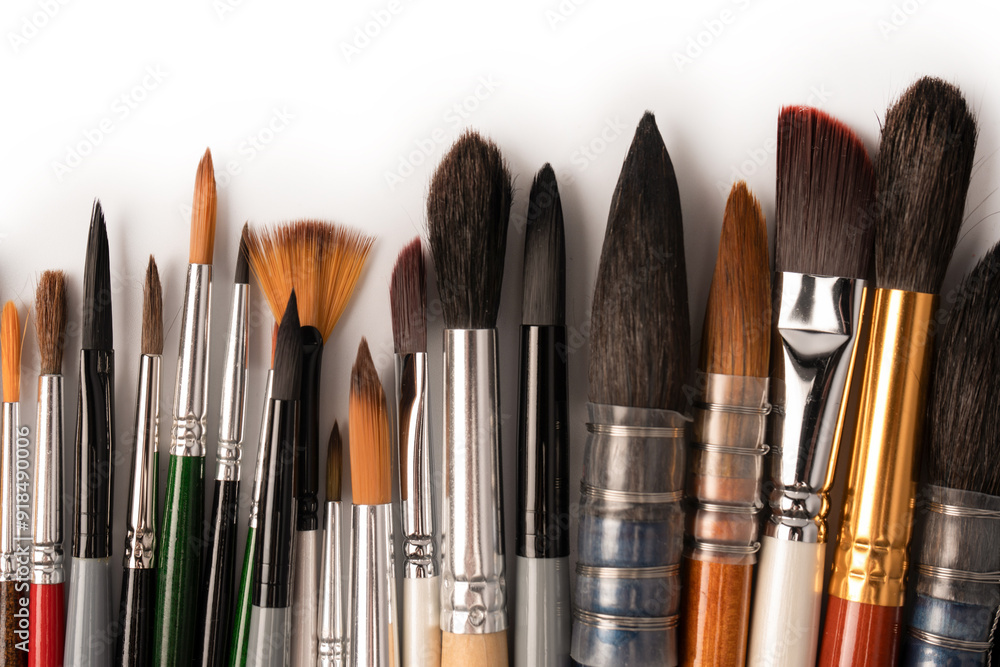 Mix of paint brushes in a row isolated on a white background. Mix of paint brushes in a row isolated on a white background.