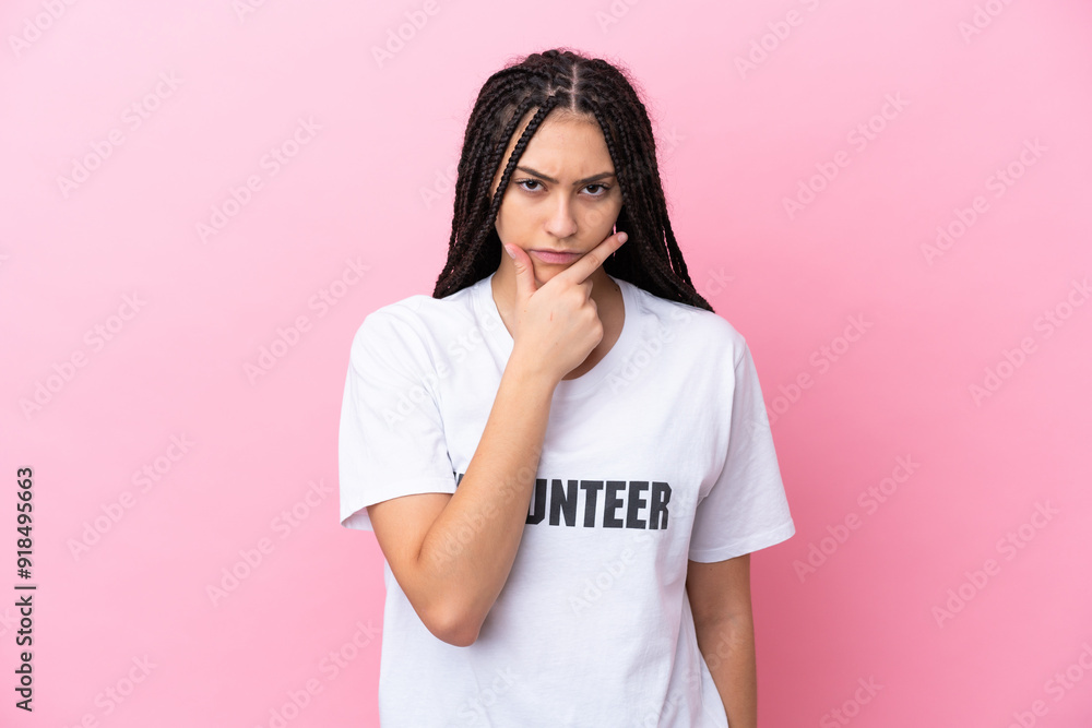 Teenager volunteer girl with braids isolated on pink background thinking Teenager volunteer girl with braids isolated on pink background thinking