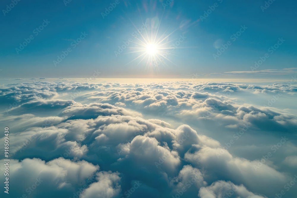 Fototapeta premium Aerial view of the sun shining in a blue sky with a blanket of clouds below, creating a heavenly feel