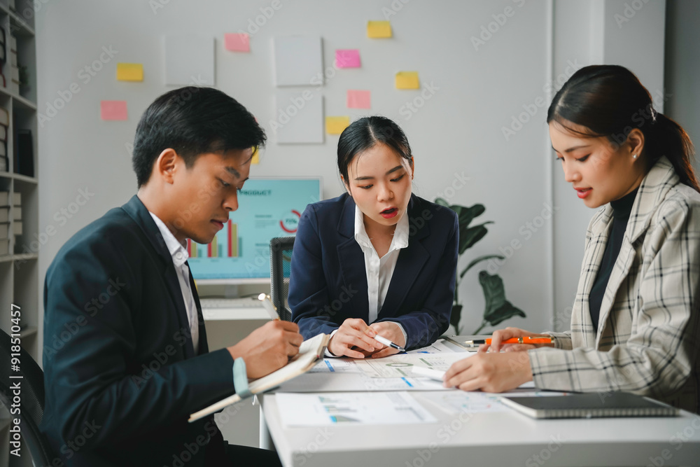 Team of young professionals is having a productive meeting, reviewing charts and discussing new business strategies Team of young professionals is having a productive meeting, reviewing charts and discussing new business strategies