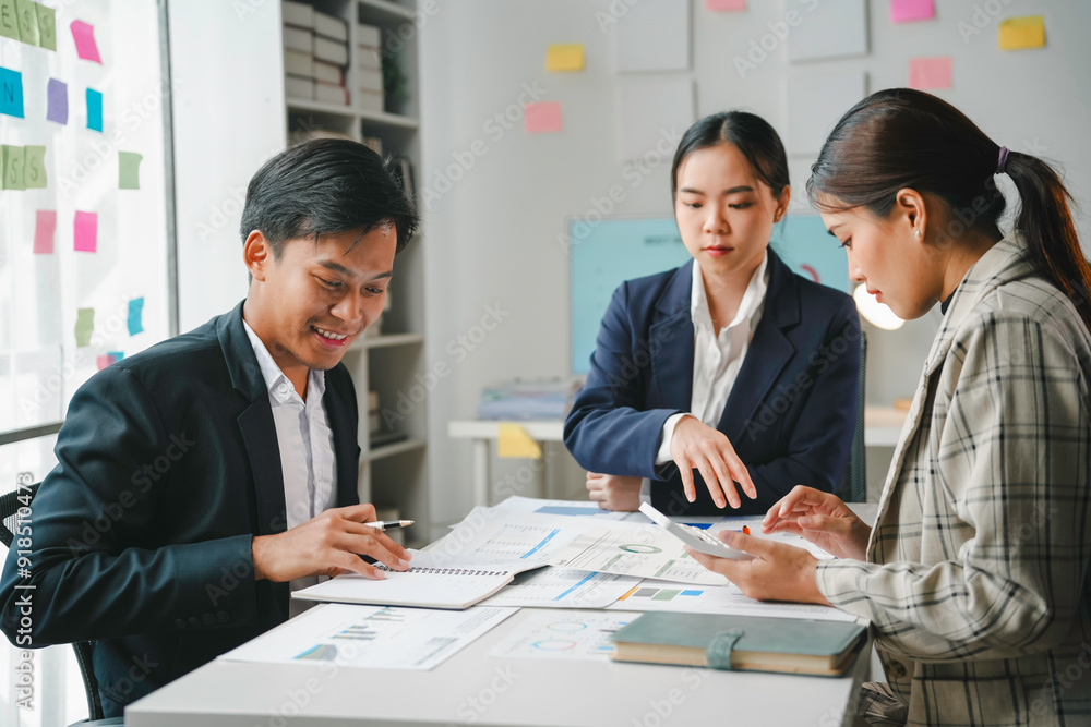 Team of asian entrepreneurs is working together, analyzing financial charts and using a calculator to calculate company profits Team of asian entrepreneurs is working together, analyzing financial charts and using a calculator to calculate company profits