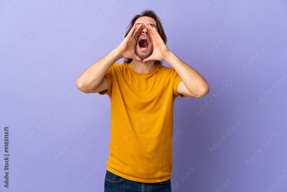 Young handsome man isolated on purple background shouting and announcing something Young handsome man isolated on purple background shouting and announcing something