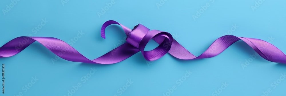 Fototapeta premium A purple ribbon tied in a bow, symbolizing elegance, celebration, gift wrapping, femininity, and love.