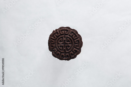 Overhead view of stamped chocolate cookies on a parchment lined baking tray, top view of embossed chocolate sugar cookies on a white background photo