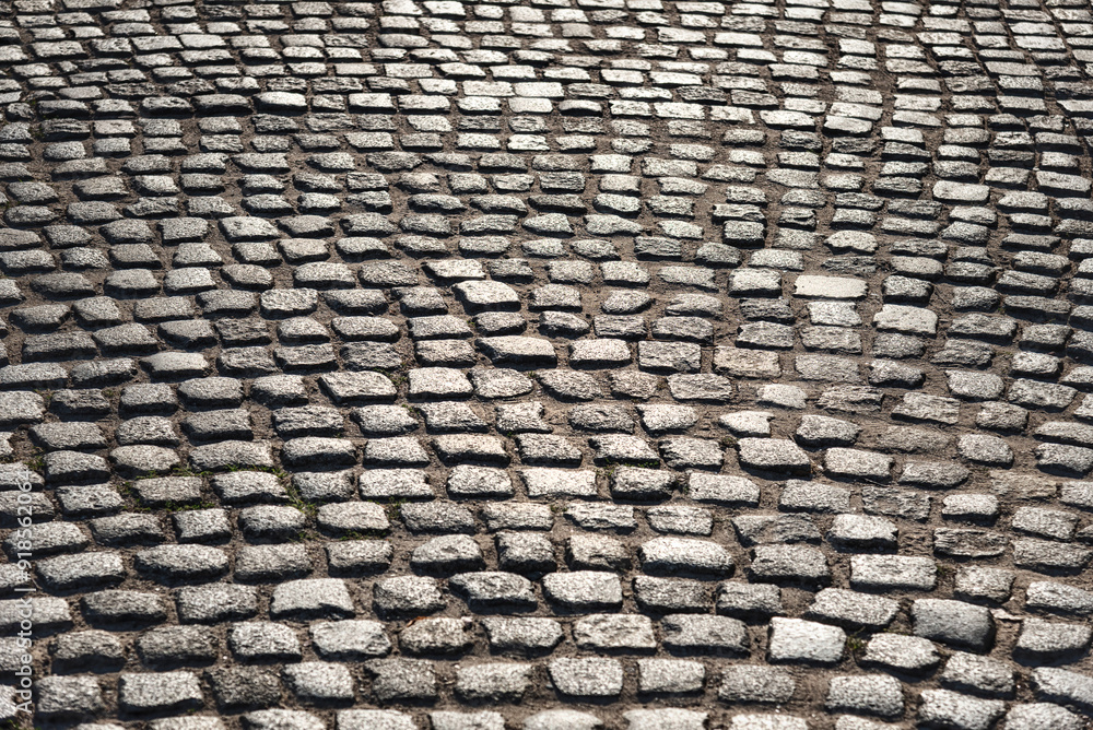 Old cobblestones with a reflection of light, background.